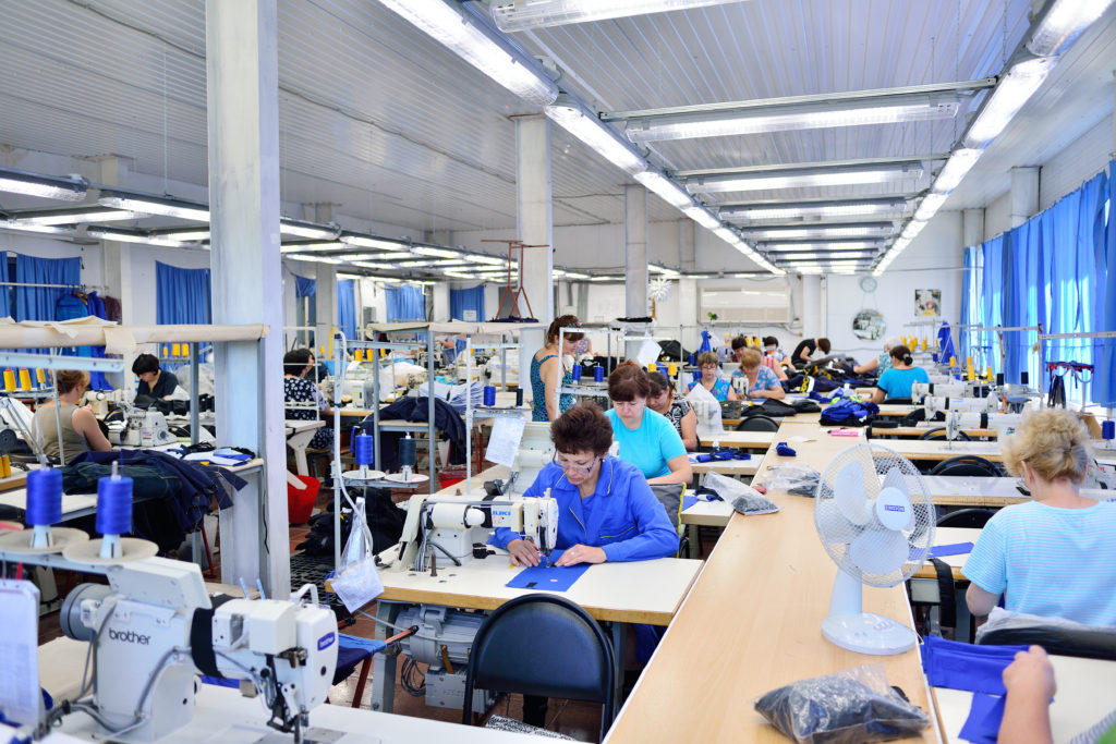 Employees sewing garments in a DTG workshop 